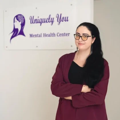 Elaine Maichin, founder of Uniquely You Mental Health Center, standing in front of her clinic's sign.