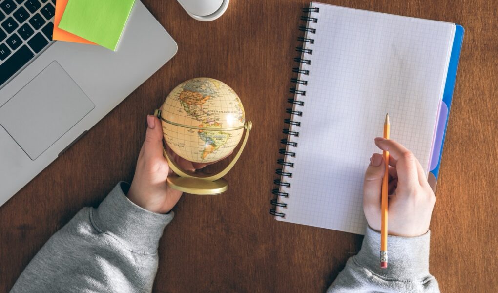Globe, laptop and notepad — planning to work abroad
