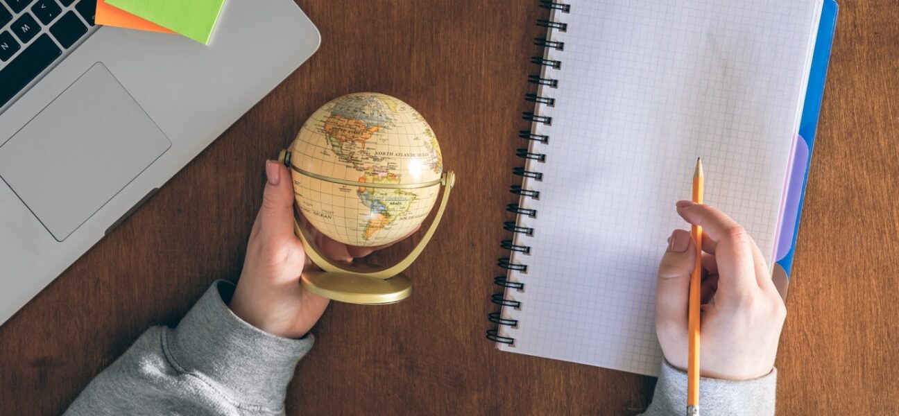 Globe, laptop and notepad — planning to work abroad