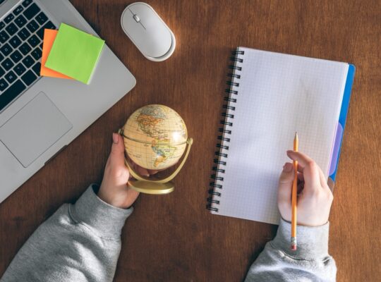 Globe, laptop and notepad — planning to work abroad