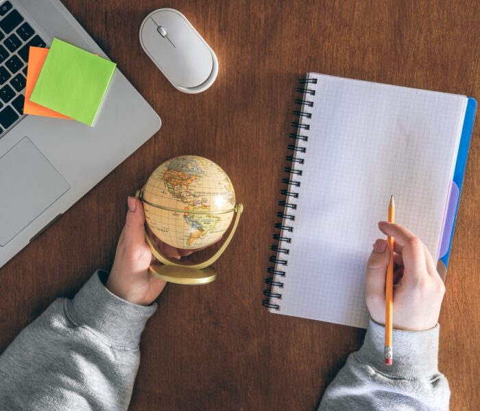 Globe, laptop and notepad — planning to work abroad